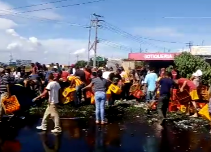 Ciudadanos se llevan gaveras con cerveza que cayeron de una gandola en la redoma El Dorado