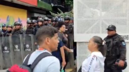 Maestros y jubilados con pancartas durante la marcha en Caracas frenada por la PNB antes de llegar a Miraflores