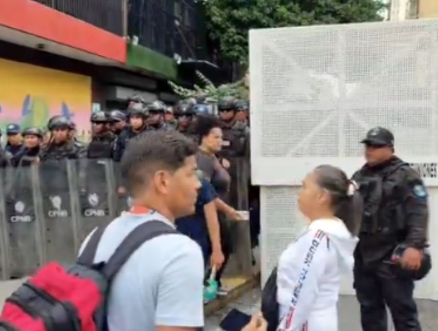Maestros y jubilados con pancartas durante la marcha en Caracas frenada por la PNB antes de llegar a Miraflores